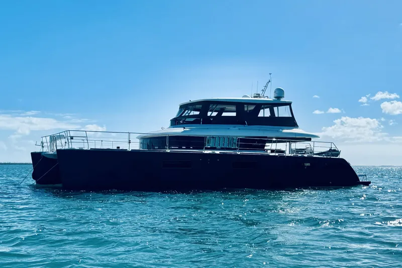 The Image of 2020 Lagoon 630 Motor Yacht cruising on open water under clear blue sky. - 0