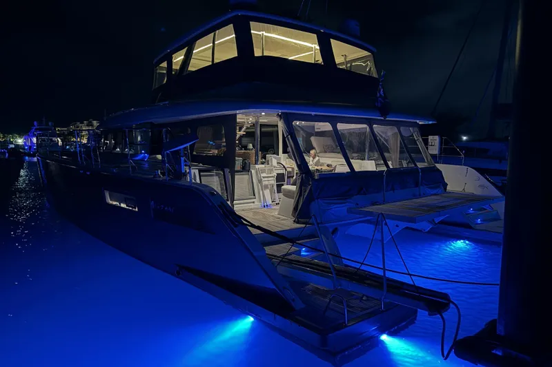 Slide: The Image of 2020 Lagoon 630 Motor Yacht illuminated at night with blue underwater lights. - 4