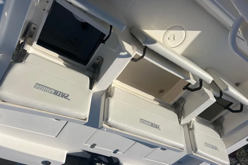 Slide: The Image of 2017 Pathfinder 2600 TRS boat with open storage compartments and cushioned seats. - 18