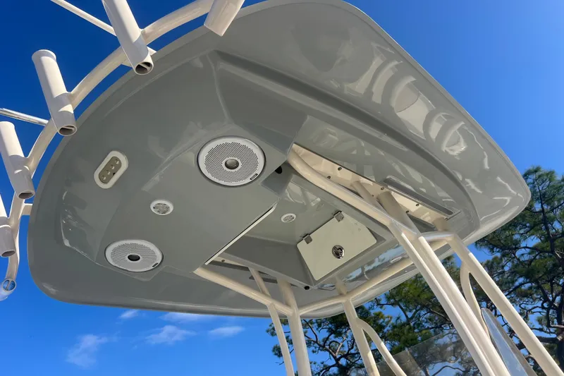 Slide: The Image of 2017 Pathfinder 2600 TRS boat T-top with speakers and rod holders against blue sky. - 20