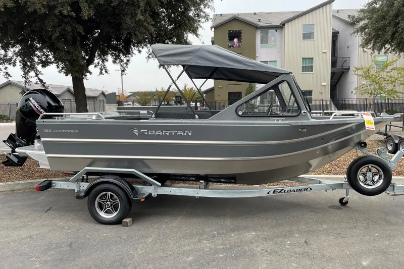 The Image of 2024 Spartan 185 Astoria boat on trailer, parked outdoors with canopy. - 0