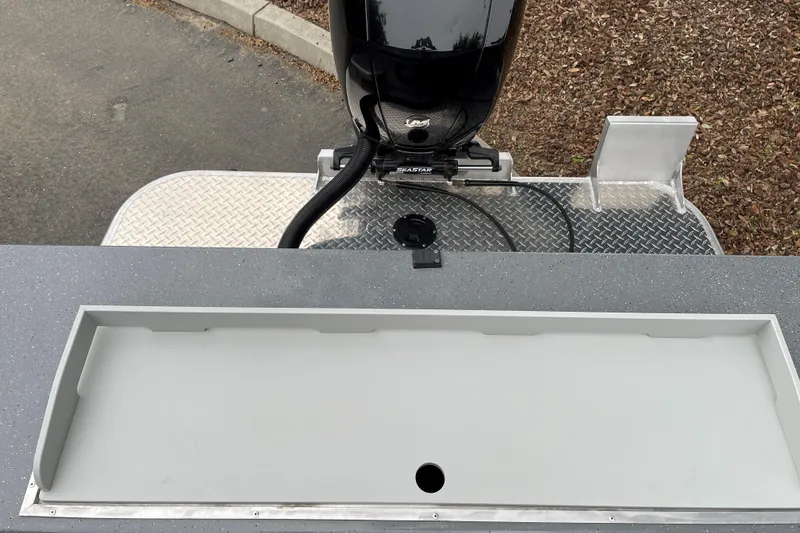 Slide: The Image of 2024 Spartan 185 Astoria boat with motor and storage compartment, featuring diamond plate flooring. - 13