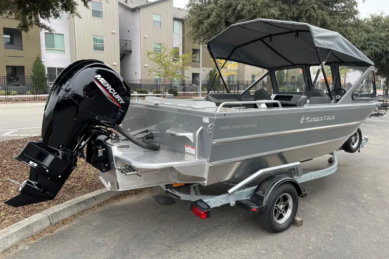 Slide: The Image of 2024 Spartan 185 Astoria boat with Mercury outboard motor, parked on a trailer. - 2