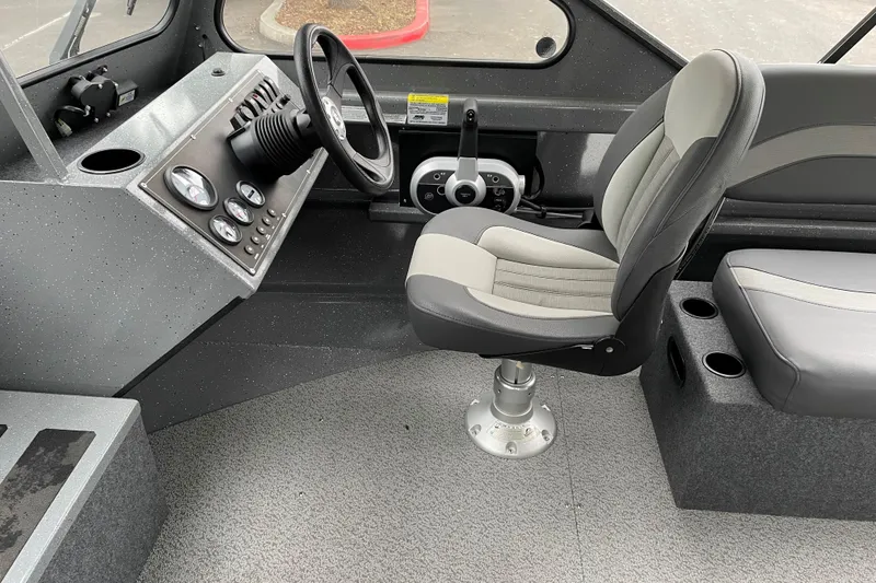 Slide: The Image of 2024 Spartan 185 Astoria boat interior with steering console and cushioned seating. - 6