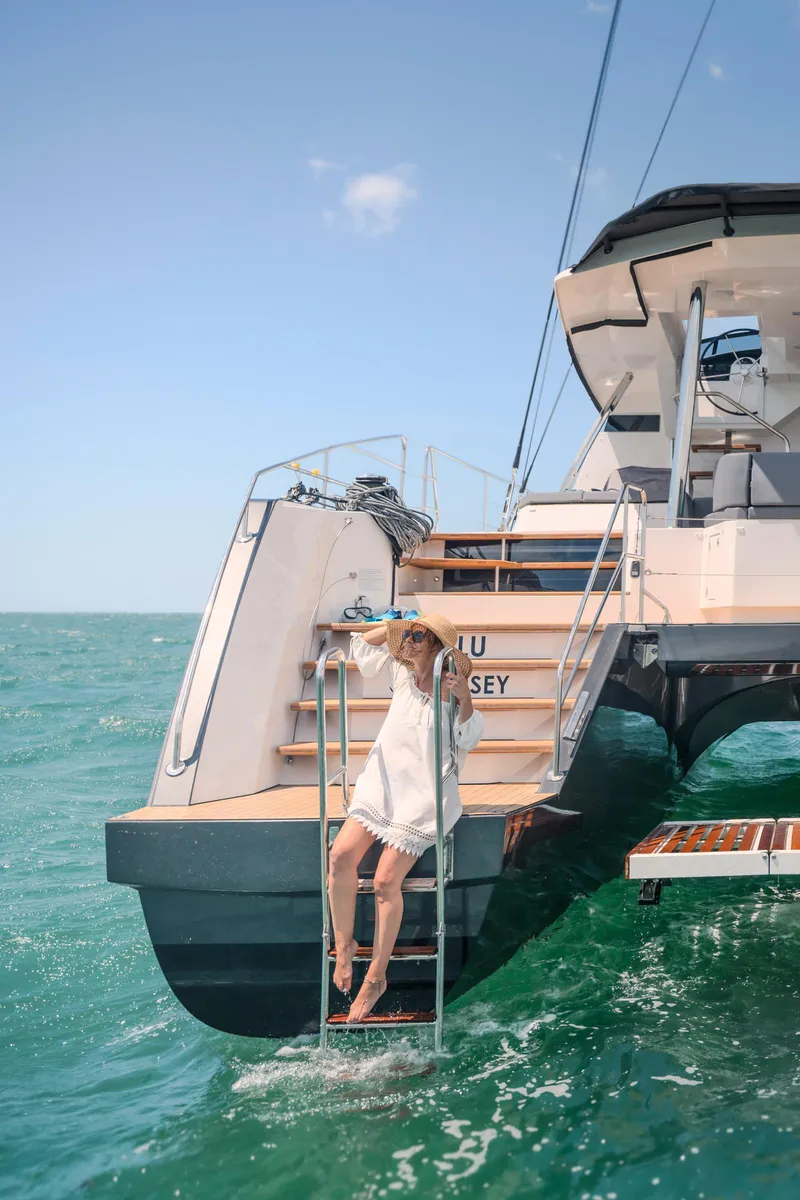Slide: The Image of Woman relaxing on a 2025 Privilege Signature 650 yacht ladder, ocean backdrop. - 7