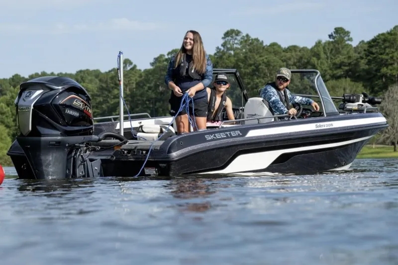 Slide: The Image of Manufacturer Provided Image: 2026 Skeeter Solera 205 boat on water with three people enjoying a sunny day. - 10