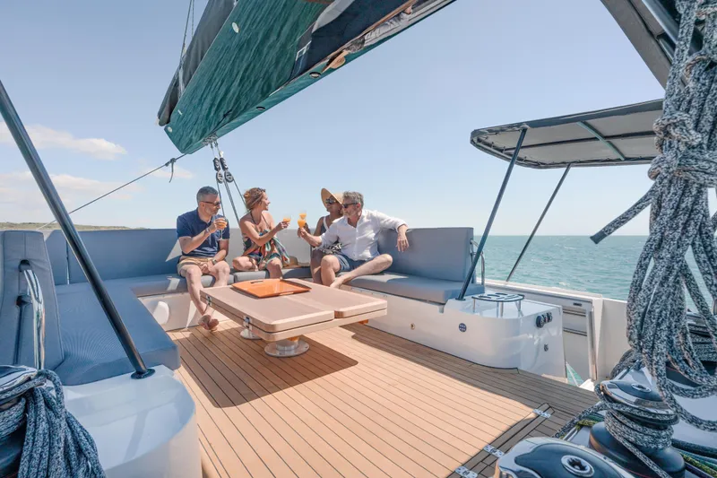 Slide: The Image of People relaxing on a 2025 Privilege Signature 650 yacht, enjoying drinks on deck. - 19