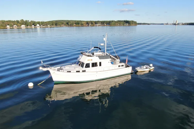 The Image of 1989 Grand Banks 46 Classic yacht on calm water, clear sky, scenic background. - 0