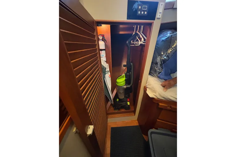 Slide: The Image of Closet interior on 1989 Grand Banks 46 Classic yacht with vacuum and hangers. - 127