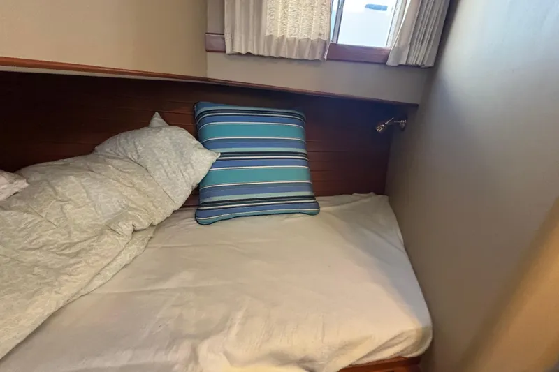 Slide: The Image of Cozy cabin bed with striped pillow on 1989 Grand Banks 46 Classic yacht. - 129