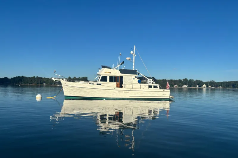 Slide: The Image of 1989 Grand Banks 46 Classic yacht on calm water under clear blue sky. - 15