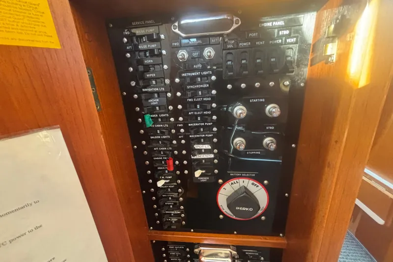 Slide: The Image of Control panel of a 1989 Grand Banks 46 Classic yacht, featuring various switches and dials. - 159
