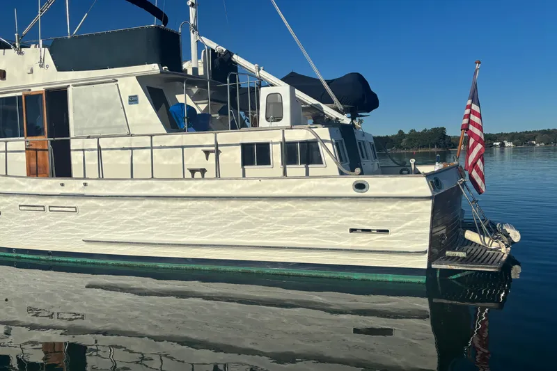 Slide: The Image of 1989 Grand Banks 46 Classic yacht on calm water with American flag. - 20