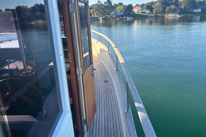 Slide: The Image of 1989 Grand Banks 46 Classic yacht on calm water, showcasing wooden deck and serene surroundings. - 28