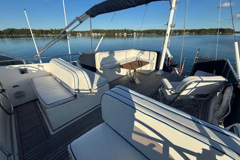 Slide: The Image of 1989 Grand Banks 46 Classic yacht deck with seating and table, overlooking calm waters. - 55