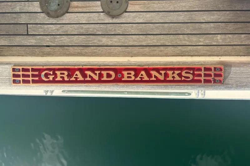 Slide: The Image of Grand Banks 46 Classic 1989 boat nameplate on wooden deck. - 59