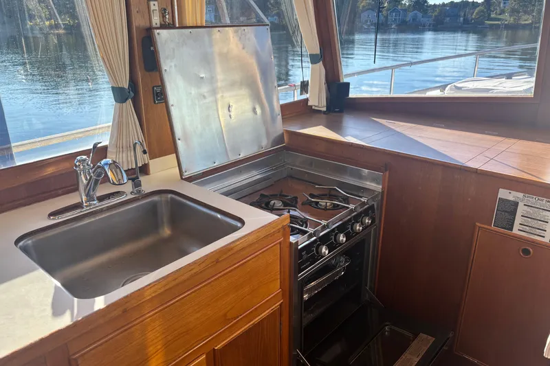 Slide: The Image of Galley kitchen in 1989 Grand Banks 46 Classic yacht with stove and sink, overlooking water. - 60