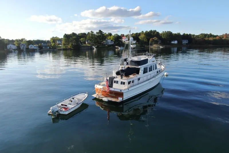 Slide: The Image of 1989 Grand Banks 46 Classic yacht anchored on serene water with a small boat nearby. - 7