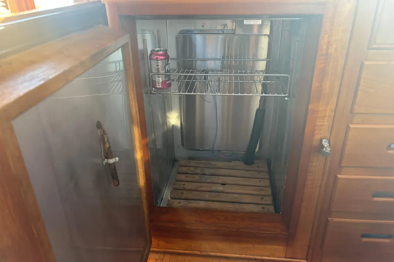 Slide: The Image of Open wooden cabinet with a single soda can inside, aboard a 1989 Grand Banks 46 Classic. - 87