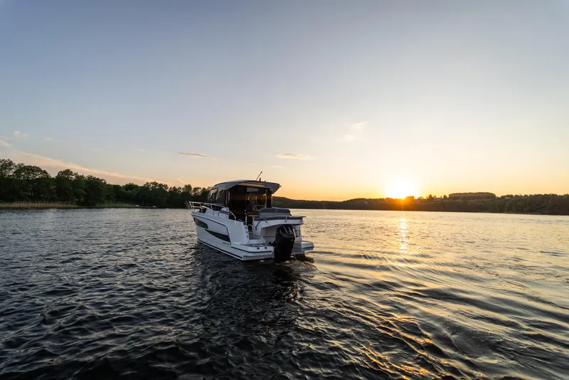 Slide: The Image of 2025 Nautic 880 boat cruising at sunset on a serene lake. - 2