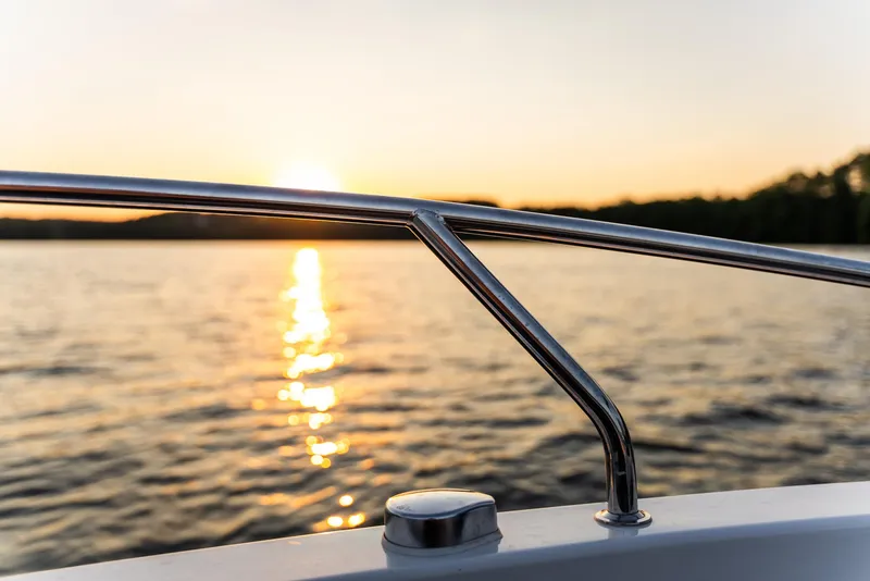 Slide: The Image of 2025 Nautic 880 yacht with elegant deck setup, featuring wine and flowers by the water. - 4