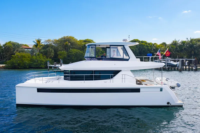 The Image of 2023 Leopard 46 Powercat yacht on serene water, surrounded by lush greenery. - 0