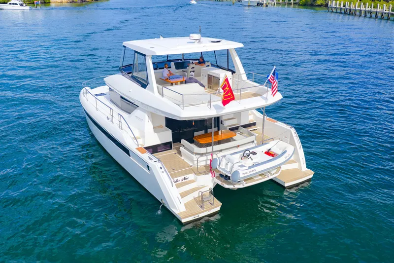 Slide: The Image of 2023 Leopard 46 Powercat yacht cruising on blue water, featuring spacious deck and flags. - 11