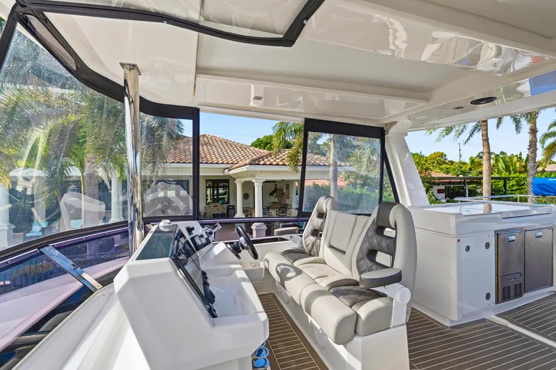 Slide: The Image of 2023 Leopard 46 Powercat cockpit with modern seating and controls, surrounded by tropical scenery. - 17