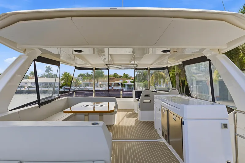 Slide: The Image of 2023 Leopard 46 Powercat interior with seating, table, and kitchenette under a canopy. - 18