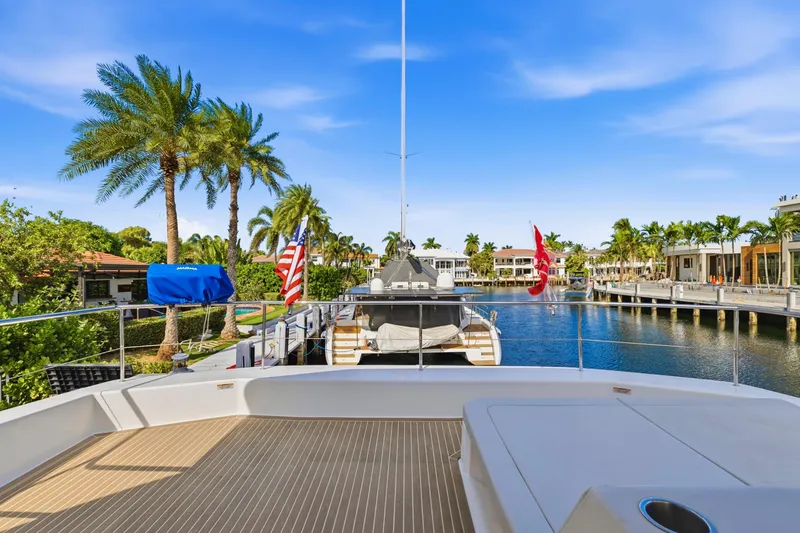 Slide: The Image of 2023 Leopard 46 Powercat yacht docked in a scenic waterfront location with palm trees. - 25