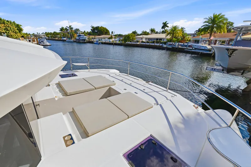 Slide: The Image of 2023 Leopard 46 Powercat yacht on a serene canal with palm trees and boats. - 29