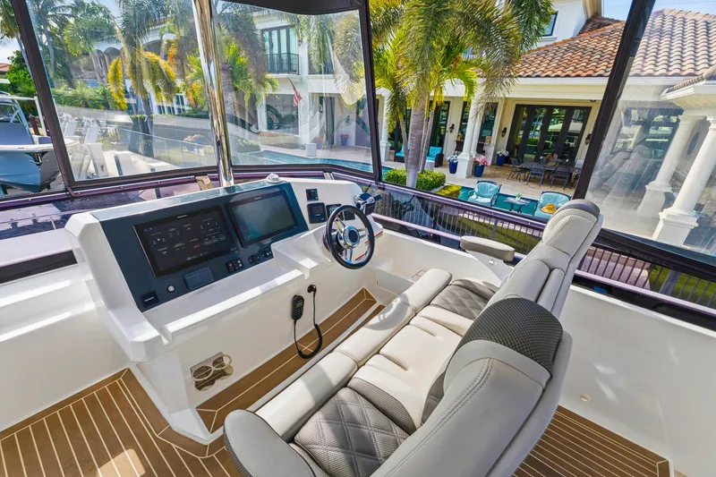 Slide: The Image of 2023 Leopard 46 Powercat helm with modern controls, luxurious seating, and waterfront view. - 3