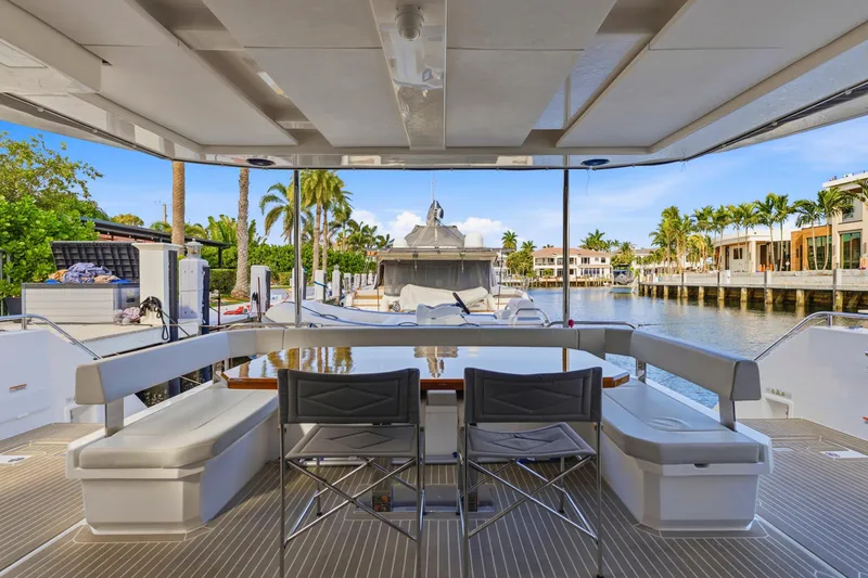 Slide: The Image of 2023 Leopard 46 Powercat yacht interior with seating, table, and waterfront view. - 32