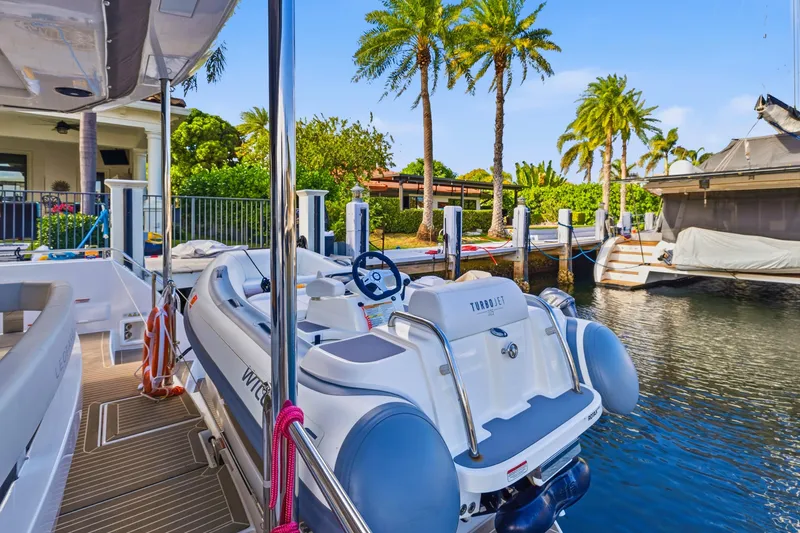 Slide: The Image of 2023 Leopard 46 Powercat docked with Turbojet tender, surrounded by palm trees. - 35