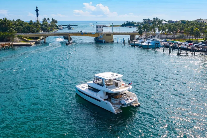 Slide: The Image of 2023 Leopard 46 Powercat cruising in a scenic coastal waterway near a lighthouse. - 4