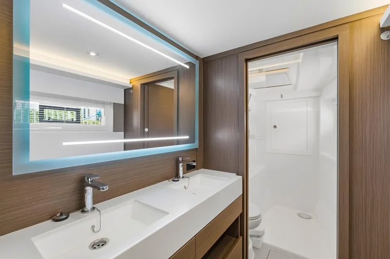 Slide: The Image of Modern bathroom in 2023 Leopard 46 Powercat yacht with dual sinks and illuminated mirror. - 49