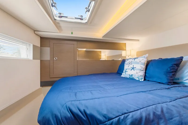 Slide: The Image of Luxurious cabin interior of 2023 Leopard 46 Powercat with blue bedding and skylight. - 54