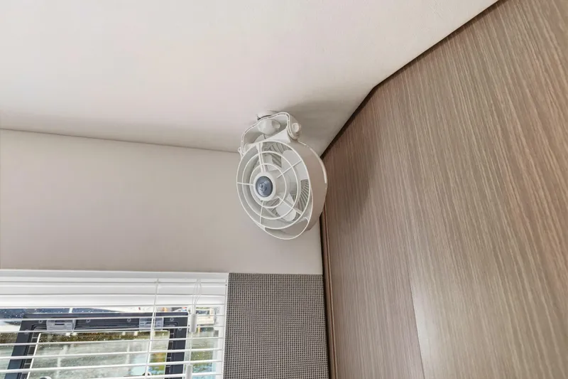 Slide: The Image of Ceiling fan in 2023 Leopard 46 Powercat interior, near window blinds and wood paneling. - 59