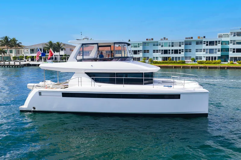 Slide: The Image of 2023 Leopard 46 Powercat yacht cruising near waterfront homes. - 7