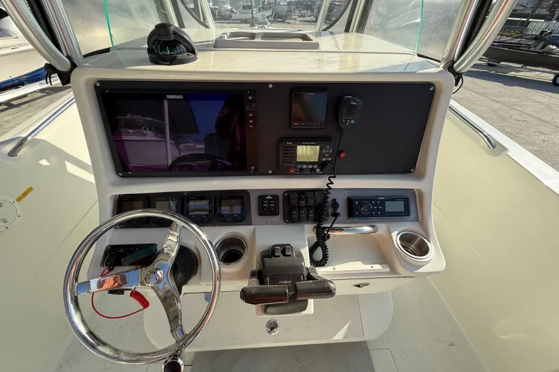Slide: The Image of 2007 Sailfish 2660 CC boat dashboard with steering wheel and navigation controls. - 14