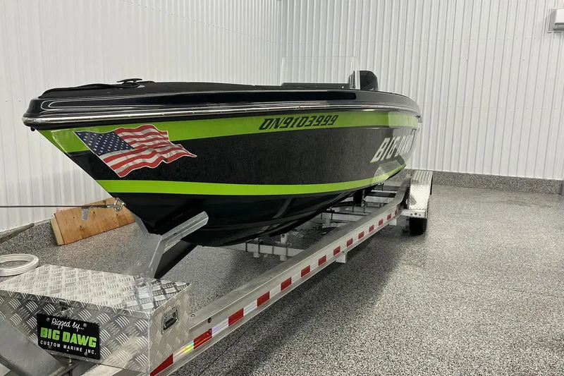 Slide: The Image of 2024 Action 23 Open boat with American flag decal on trailer in garage. - 1