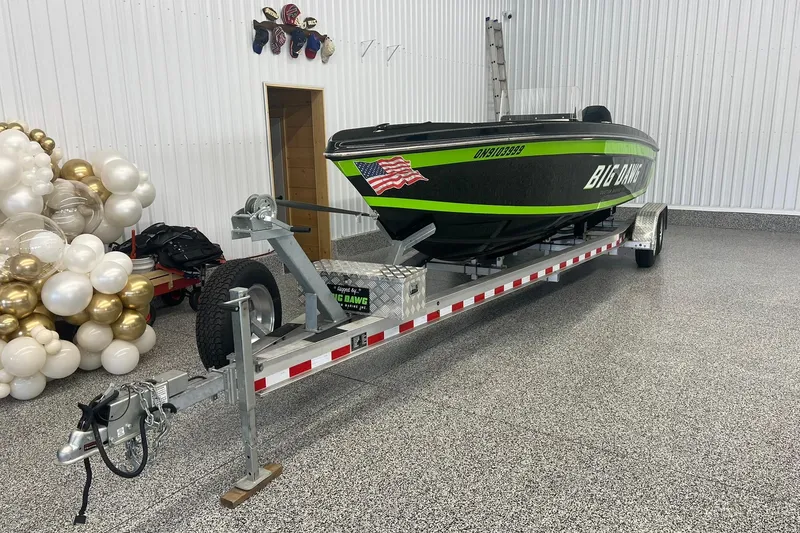 Slide: The Image of 2024 Action 23 Open boat on trailer in showroom with decorative balloons. - 2