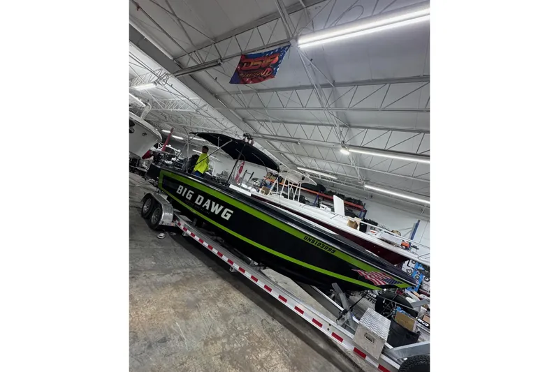 Slide: The Image of 2024 Action 23 Open boat "Big Dawg" on trailer in indoor showroom. - 6