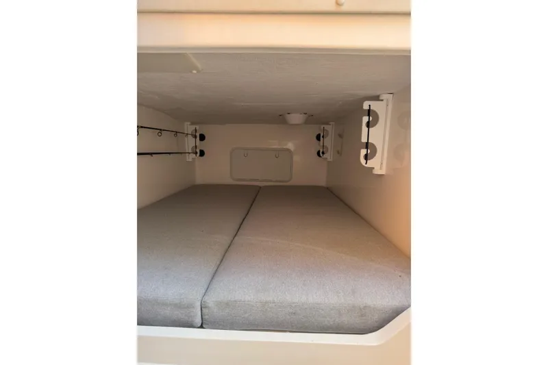 Slide: The Image of 2024 NorthCoast 285 HT cabin interior with cushioned sleeping area and rod holders. - 13