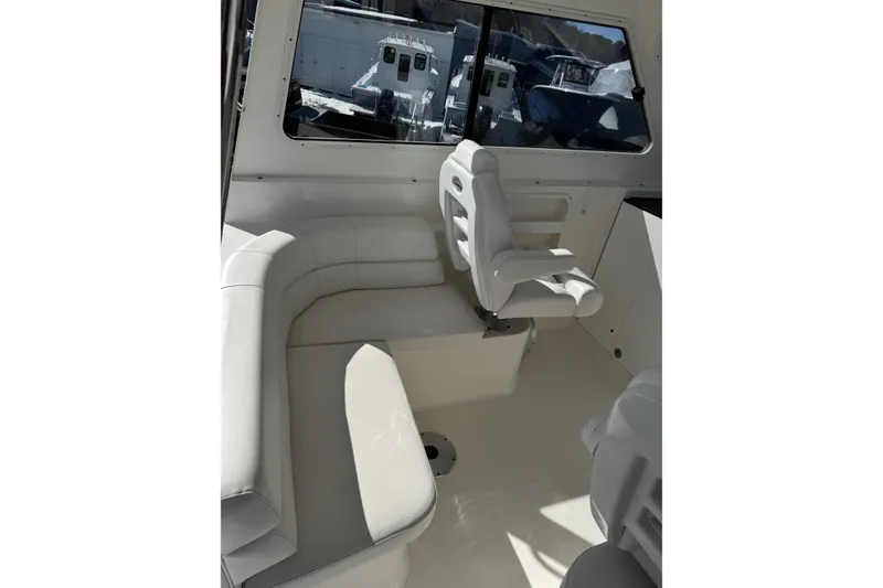 Slide: The Image of Interior of 2024 NorthCoast 285 HT boat with white seating and windows. - 8