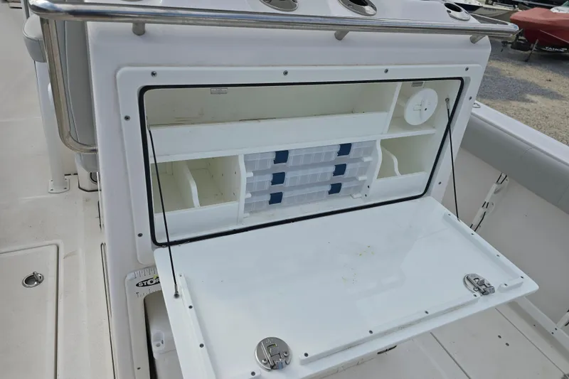 Slide: The Image of 2023 Sea Fox 288 Commander boat storage compartment with organized shelves and tackle boxes. - 11