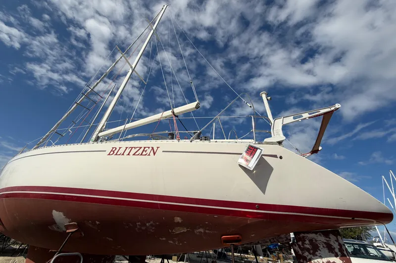 Slide: The Image of 1983 Morgan Catilina sailboat "Blitzen" on land under a blue sky. - 1