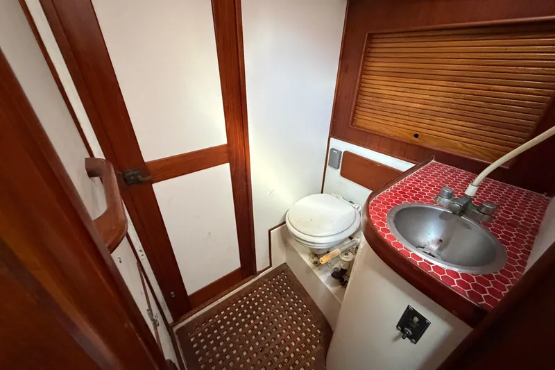 Slide: The Image of 1983 Morgan Catilina boat bathroom with red-tiled sink and wooden accents. - 108