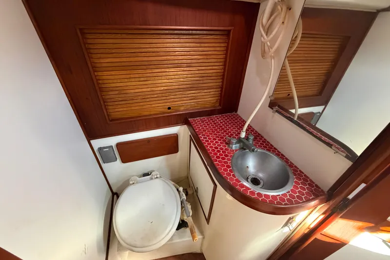 Slide: The Image of 1983 Morgan Catilina yacht bathroom with red-tiled sink and wooden accents. - 110