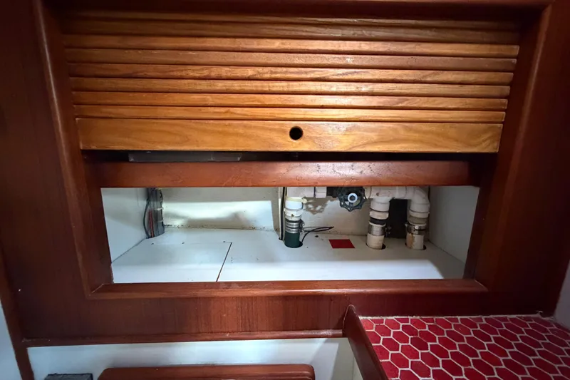 Slide: The Image of 1983 Morgan Catilina interior with wooden cabinetry and visible plumbing components. - 112